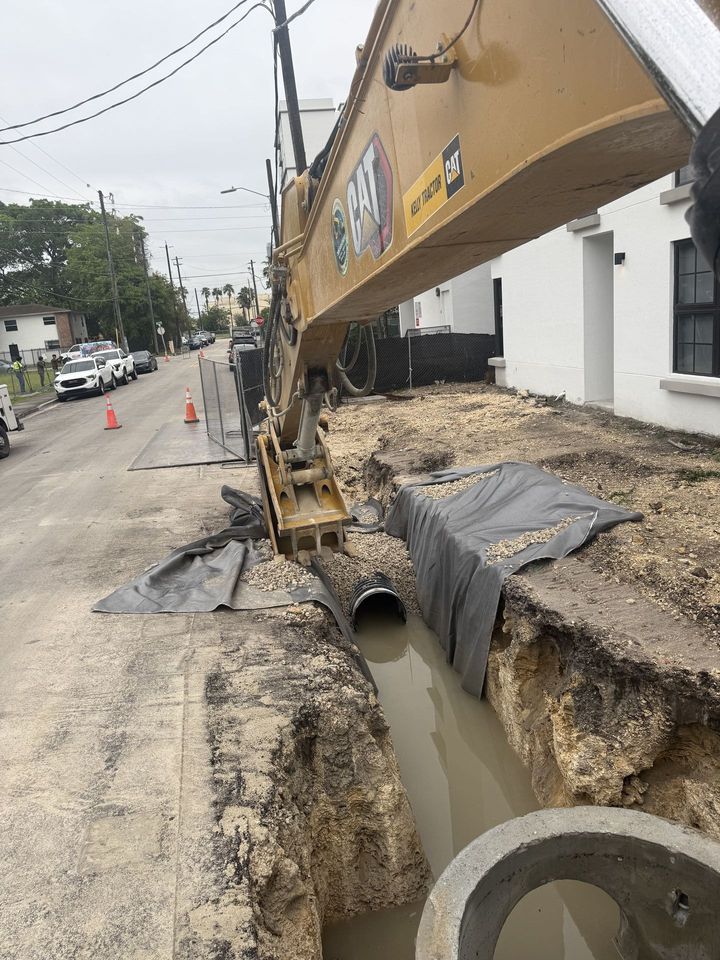 Excavator working a street trench with pipe in place